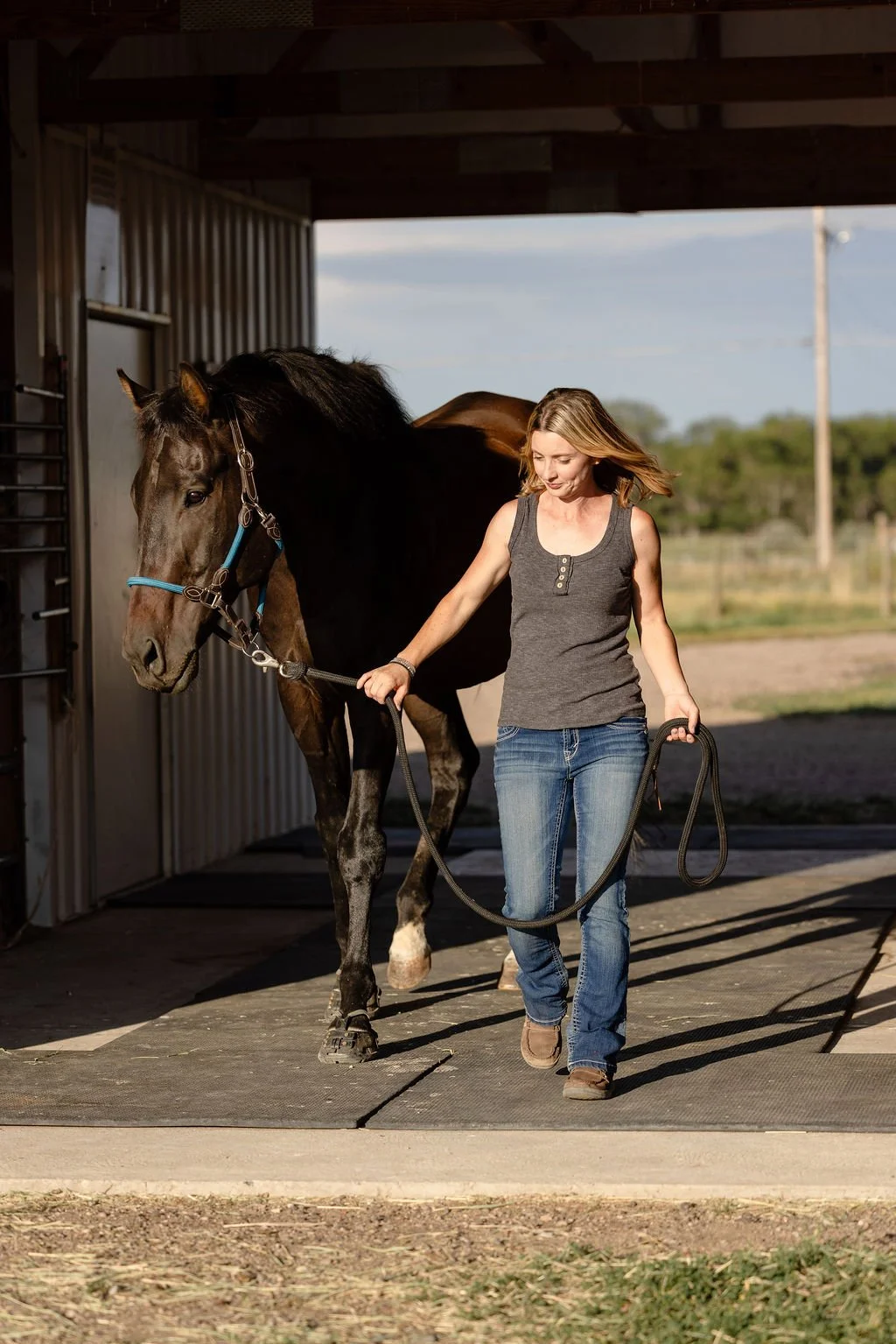 Nicole walking a horse out to the barn aisle at HeartSong Equine